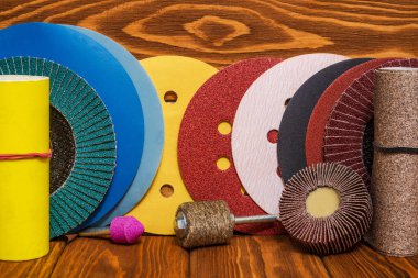 Büyük aşındırıcı aletler seti ve ahşap vintage arka planda çok renkli zımpara kağıdı