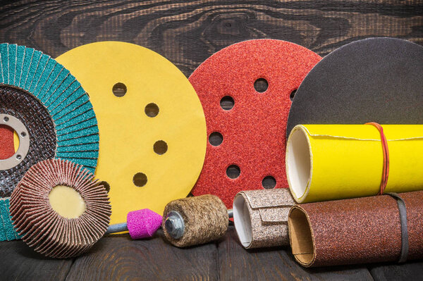 Big set of abrasive tools and multicolored sandpaper on wooden vintage black background