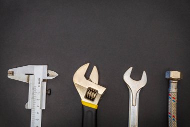 Siyah arka planda tesisatçılar için gerekli araçlar ve reklam için alan