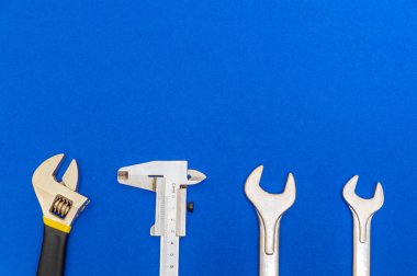 Mavi arka planda tesisatçılar için gerekli araçlar ve reklam için alan