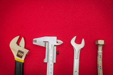 Kırmızı zemin üzerinde tesisatçılar için gerekli araçlar ve reklam için alan