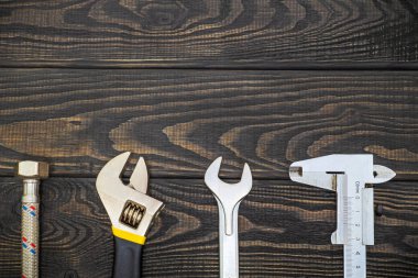 Tesisatçılar için gerekli aletler siyah tahta tahtalarda reklam için yer var.