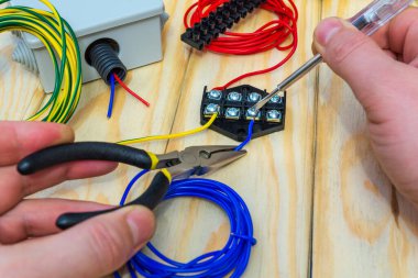 Üstat bağlanmak için bir elektrikli alet ve kablolar tutuyor