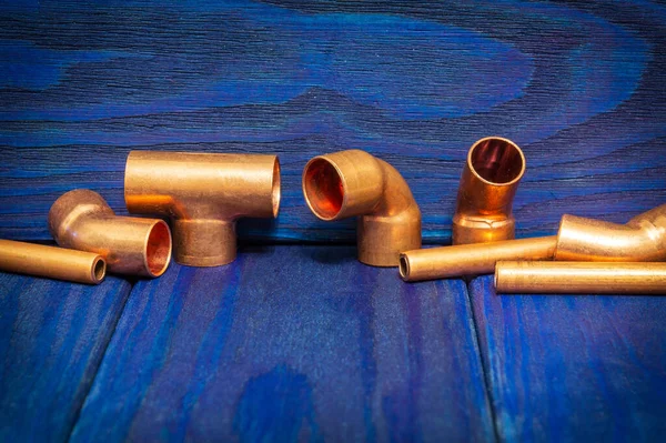 Copper water pipe fittings plumbing concept or repair water supply on blue wooden boards