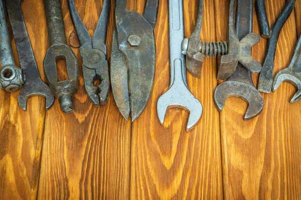 Old tools stacked after work on vintage wood background