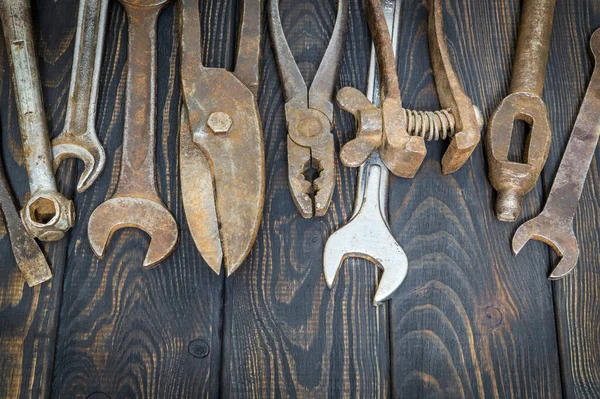 Many old tools stacked after work on black vintage wooden boards — Stock Photo, Image