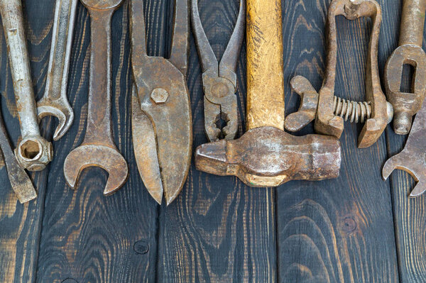 Many old tools stacked after work on black vintage wooden boards