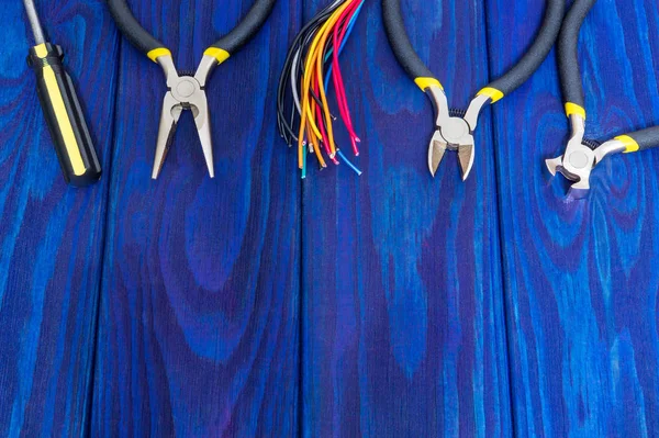 Narzędzia elektryczne i kable na niebieskich drewnianych płytach — Zdjęcie stockowe
