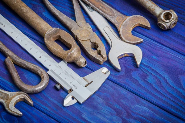 Many vintage craftsman tools stacked after work on blue wooden boards — Stock Photo, Image
