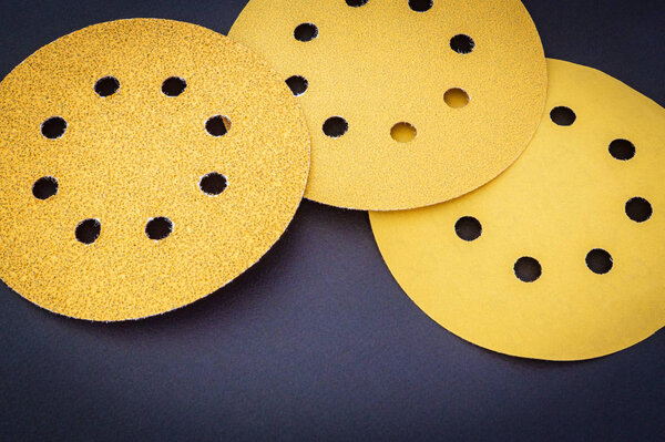 Set of yellow abrasive tools on black background