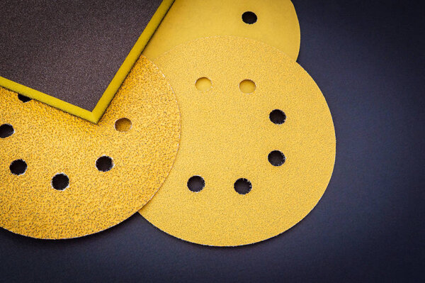 Set of yellow abrasive tools on black background