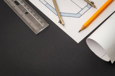 İnşaat çiziminde yalan söylemek için yuvarlanmış ev şemaları ve aksesuarları