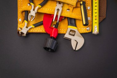 Profesyonel usta tarafından onarım ya da inşaattan önce hazırlanmış siyah arkaplan üzerine süet çantada büyük araçlar.