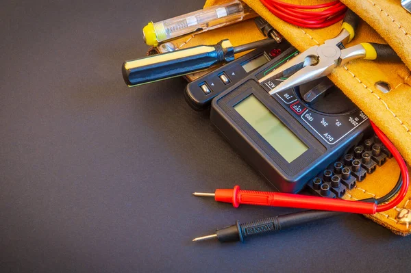 Gran juego de herramientas en bolsa de gamuza sobre fondo negro preparado por el maestro electricista antes de la reparación o construcción —  Fotos de Stock