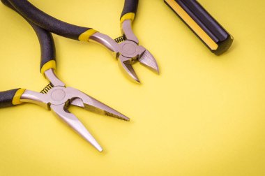Enerji verilmiş sistemleri veya iletişimi onarmak için sarı arka planda yeni bir elektrikçi aracı
