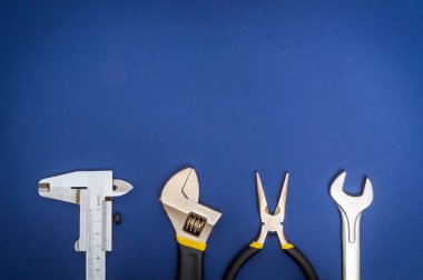 Tamir veya inşaattan önce profesyonel usta tarafından hazırlanan mavi arka plandaki inşaatçılar için büyük araçlar