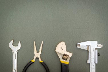 Tamir veya inşaattan önce profesyonel usta tarafından hazırlanmış karanlık bir atölye masasında tesisatçı için bir takım aletler.