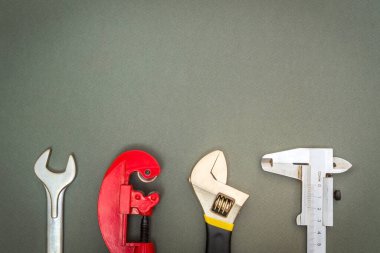 Tamir ya da inşaattan önce profesyonel usta tarafından hazırlanmış karanlık bir atölye masasında tesisatçı için büyük aletler.