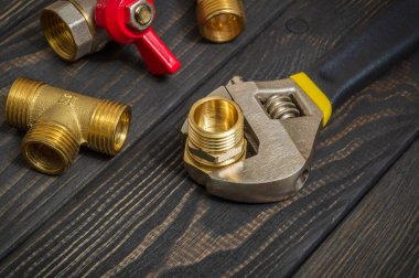 Boru tesisatı tesisatı ve ayarlanabilir anahtarlar yedek parçaların onarımı ya da yenilenmesi sırasında siyah tahta tahtalara yakın çekim yapıyor.