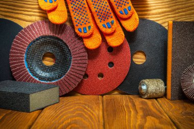 Kaliteli tahta tahtalar üzerinde aşındırıcı aletler ve sarı iş eldivenleri olan bir sihirbaz, nesneleri öğütmek için kullanılır.