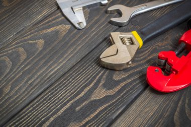 Tamir ya da inşaattan önce profesyonel usta tarafından hazırlanan siyah, eski tahta tahtalar üzerinde tesisatçı için büyük aletler.