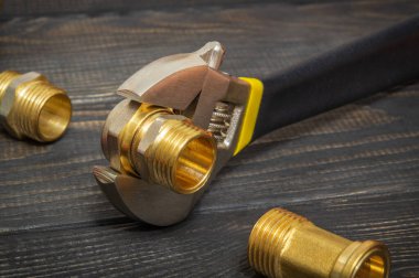 Boru tesisatı tesisatı ve ayarlanabilir anahtarlar yedek parçaların onarımı ya da yenilenmesi sırasında siyah tahta tahtalara yakın çekim yapıyor.