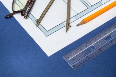 Proje mühendisliği işleri için inşaat çizimi ve mavi atölye masasına uzanan yuvarlak ev şemaları ve aksesuarları