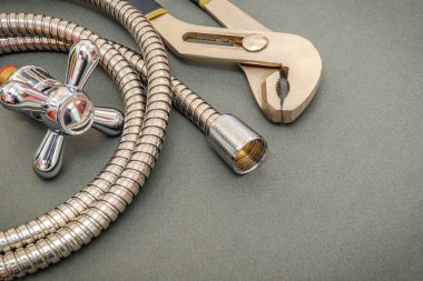 Su tesisatı musluğu, araç ve hortum koyu yeşil arka planda duş yenileme için kullanılır