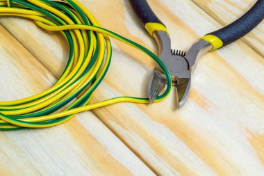 Elektrikçinin aleti ve kablosu, enerjili sistemleri veya iletişimi onarmak için tahta bir tahtanın üzerine kurulmuş.