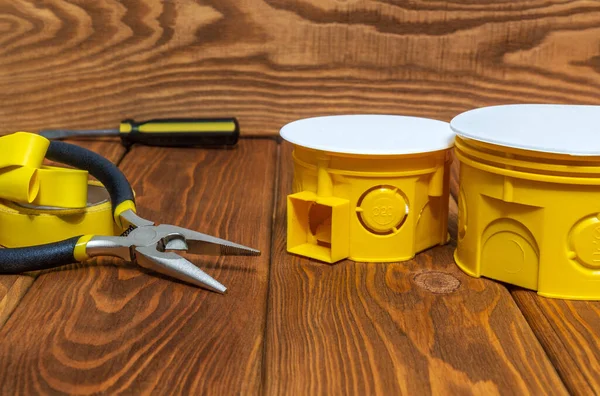 Комплект желтых запасных частей для электрооборудования и инструментов, приготовленных на старинных деревянных досках перед ремонтом или установкой — стоковое фото