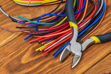 Elektrikçi aracı ve eski ahşap tahtalardaki kablolar enerjili sistemleri veya iletişimi onarmak için