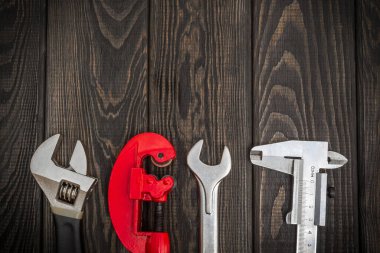 Tamir ya da inşaattan önce profesyonel usta tarafından hazırlanmış, siyah tahta tahtalardaki bir tesisatçı için alet takımı.