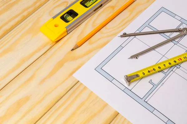Accessories and drawing tools lie on building project or wooden boards