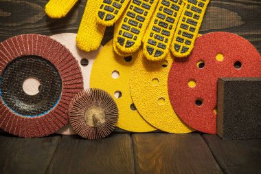 Koyu renkli ahşap tahta tahtalar üzerinde aşındırıcı aletler ve sarı iş eldivenleri seti. Sihirbaz nesneleri öğütmek için kullanılır.