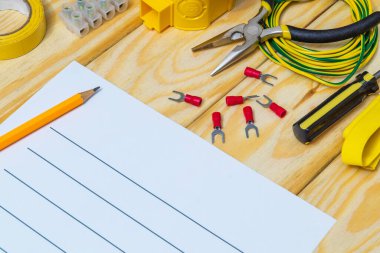 Tahta tahtalarda yedek parça ve aletlerle elektrik teçhizatının onarımı için plan çiziliyor