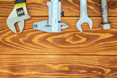 Tesisatçılar için gerekli aletler ve hortum reklam için yeri olan eski ahşap tahtalar.