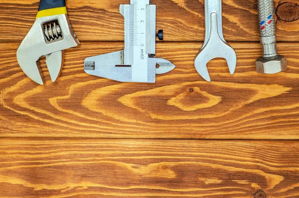 Tesisatçılar için gerekli aletler ve hortum reklam için yeri olan eski ahşap tahtalar.