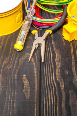 Kablolu elektrik bağlantı kutusu ve genellikle siyah vintage tahtalardaki elektrik kurulum sürecinde kullanılan araçlar