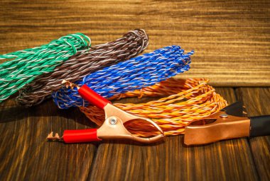 Çok renkli kablolar ve timsah derisi klipler eski ahşap tahtalardaki usta elektrikçi için hazırlandı.