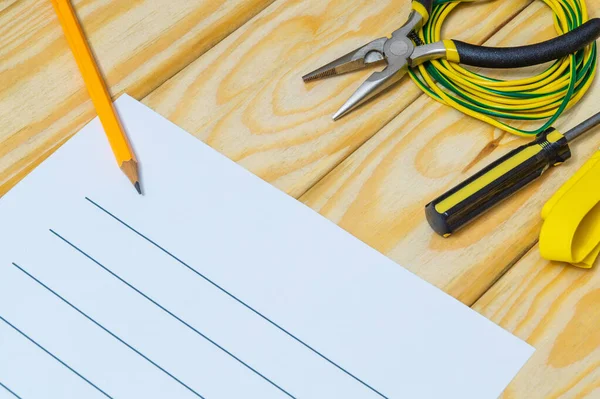 Tahta tahtalarda yedek parça ve aletlerle elektrik teçhizatının onarımı için plan çiziliyor