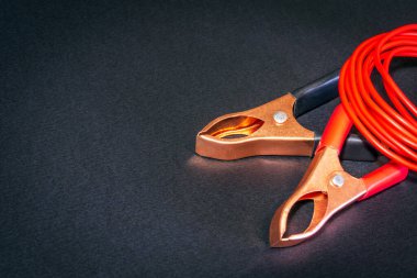 Kırmızı kablolar ve timsah klipleri siyah arka plandaki usta elektrikçi için hazırlandı.