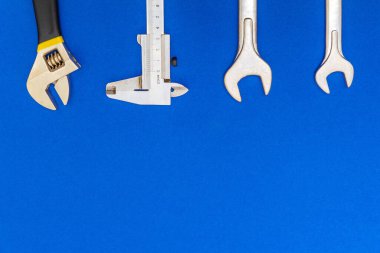 Tesisatçılar için gerekli alet ve hortum seti mavi arka planda ve reklam için yer var.