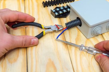 Üstat bağlanmak için farklı renkte elektrik ve kablolar tutuyor