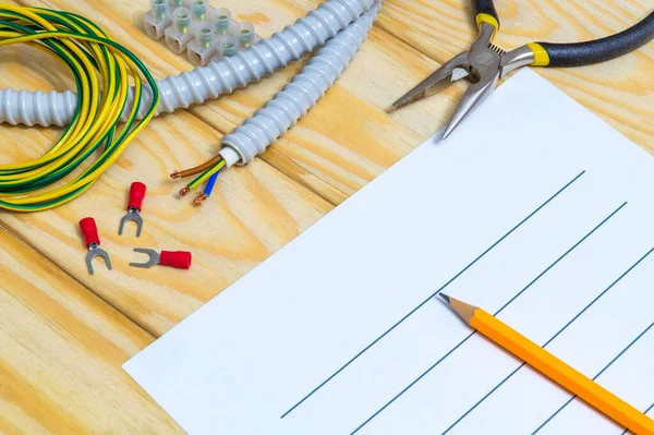 Tahta tahtalarda yedek parça ve aletlerle elektrik teçhizatının onarımı için plan çiziliyor