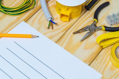 Tahta tahtalarda yedek parça ve aletlerle elektrik teçhizatının onarımı için plan çiziliyor