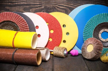 Tahta ahşap zemin üzerinde aşındırıcı aletler ve çok renkli zımpara kağıdı seti. Sihirbaz nesneleri öğütmek için kullanılır.