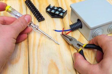 Üstat bağlanmak için farklı renkte elektrik ve kablolar tutuyor