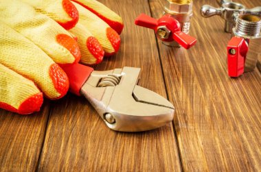 İş eldivenleri ve tesisatçı aletleri tamir edilmeden önce ahşap tahtalara bağlanır.