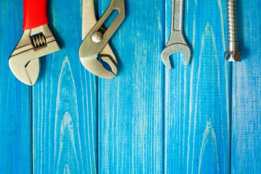 Mavi tahta üzerinde tesisatçılar için profesyonel alet ve hortum seti