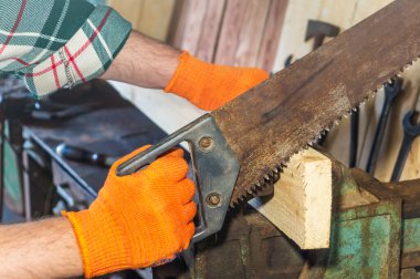 Usta testere ile tahta keser, atölyedeki çalışma ortamı